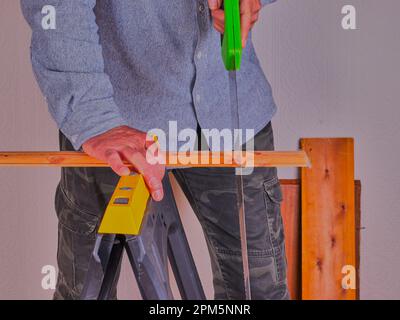 Persona che sega un pezzo di legno su un banco di sega. Foto Stock