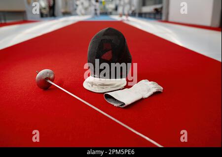 Spada di scherma, casco protettivo con maschera e guanti in pelle Foto Stock