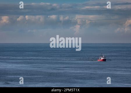 Una taglierina con reti di trascinamento sollevate sul mare del Nord vicino alla spiaggia Foto Stock