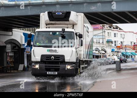 Enterprise Flex e Rent autocarro a noleggio che guida attraverso l'acqua piovana sotto Southend Pier, Southend on Sea, Essex, Regno Unito. Veicolo a noleggio Foto Stock