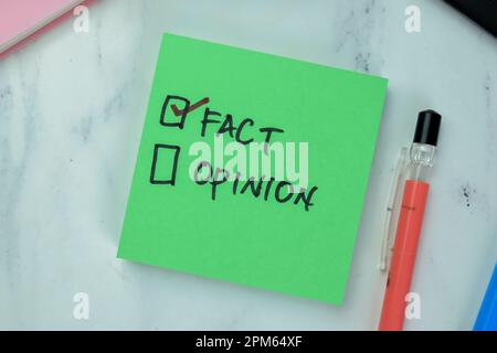 Concetto di fatto e di opinione scrivere su note appiccicose isolate su Tavola di legno. Foto Stock
