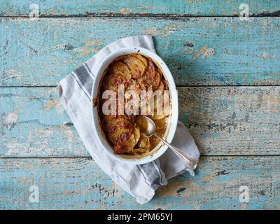 Vista dall'alto immagine del gratin di patate in teglia bianca su sfondo di legno con spazio copia Foto Stock