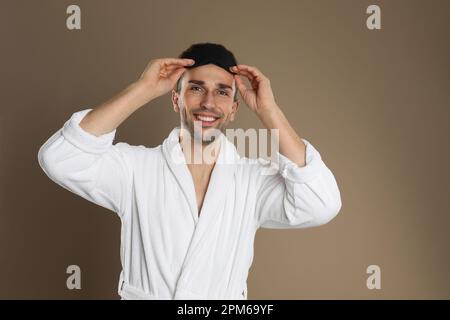 Uomo in nero accappatoio in piedi alla finestra Foto stock - Alamy