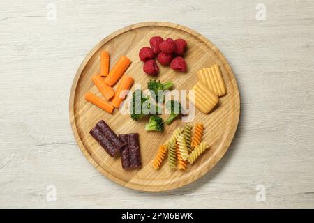 Tavola con diversi alimenti per le dita per il bambino su un tavolo di legno, vista dall'alto Foto Stock