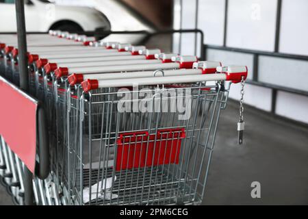 Fila di carrelli di metallo vuoti vicino al supermercato all'aperto Foto Stock