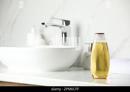 Bottiglia di shampoo vicino al lavandino sul banco del bagno, spazio per il testo Foto Stock