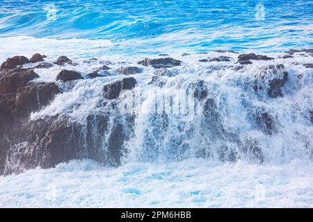 Onde oceaniche sulle rocce . Cascata d'acqua nell'oceano Foto Stock