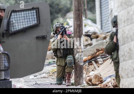 Nablus, Palestina. 11th Apr, 2023. Un soldato israeliano punta la sua arma in una casa, durante un'operazione militare, dopo che le forze armate israeliane hanno ucciso uomini da guerra palestinesi, vicino a Elon Moreh, ad est di Nablus, in Cisgiordania. Credit: SOPA Images Limited/Alamy Live News Foto Stock