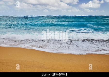 Onde oceaniche che si infrangono su una spiaggia di sabbia Foto Stock