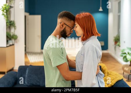 Coppia millenaria multirazziale innamorata che abbraccia il proprio paese, rendendo la pace dopo la lotta Foto Stock