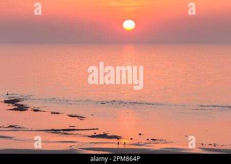 Francia, Seine-Maritime, Veules-les-Roses, elencati come uno dei più bei villaggi di Francia, mare, tramonto e sagome di una coppia a piedi nel mare Foto Stock