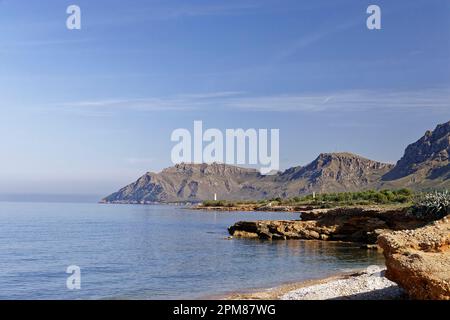 Spagna, Isole Baleari, Maiorca, Baia di Alcúdia, Colonia de Sant Pere, Playa Cala Camps Vells e le sue acque trasparenti, sullo sfondo il Parco Naturale del Península de Llevant e le montagne Foto Stock