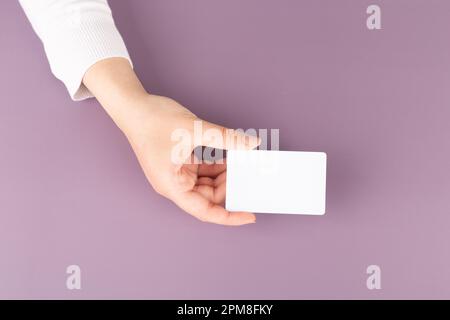 la mano di una donna mostra una carta vuota. Spazio per la pubblicità Foto Stock