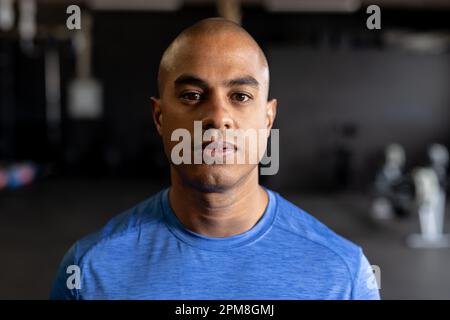 Primo piano di un giovane fidato biraciale con testa rasata in palestra Foto Stock