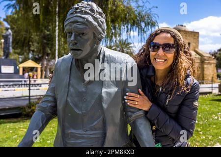 Nelin Tunc al monumento a suo padre Kemal Tunc. Il noto attore e autore morì nel 2007. Il monumento si trova vicino alla porta Kyrina a Nicosia e commemora il popolare programma radiofonico e suona Alikko e Caher, sulla vita dei turcociprioti intorno al 1964. Lefkoşa Türk Belediyesi, Cipro Foto Stock