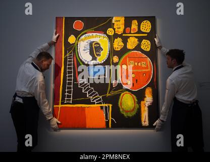 Tecnici della galleria che tengono un dipinto di Jean-Michel Basquiat, Moon View, 1984, con una stima di 7-10 milioni di dollari, in mostra durante un invito fotografico per i momenti salienti del film di Sotheby di maggio, in vista della loro asta a New York il mese prossimo. Data immagine: Mercoledì 12 aprile 2023. Foto Stock