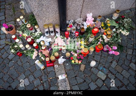 Wunsiedel, Germania. 12th Apr, 2023. Fiori, giocattoli e luci di tomba si trovano sul marciapiede all'angolo della strada che conduce al Centro servizi per i Bambini e i giovani, dove una ragazza di dieci anni è stata trovata morta. Credit: Daniel Vogl/dpa/Alamy Live News Foto Stock