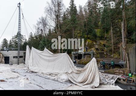 Wunsiedel, Germania. 12th Apr, 2023. Il tetto della tenda viene tirato in aria con un verricello a cavo. Il tetto della tenda di 1600 metri quadrati, originariamente progettato dall'architetto Frei otto, è innalzato sopra l'auditorium del Festival Theater. Credit: Daniel Vogl/dpa/Alamy Live News Foto Stock