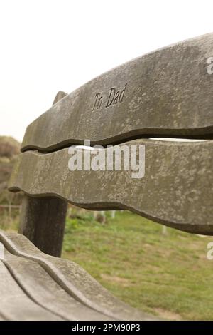 Primo piano di una panchina commemorativa che si affaccia sulla Croyde Bay, North Devon Foto Stock