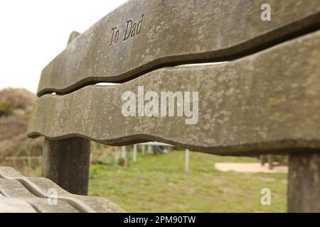 Primo piano di una panchina commemorativa che si affaccia sulla Croyde Bay, North Devon Foto Stock