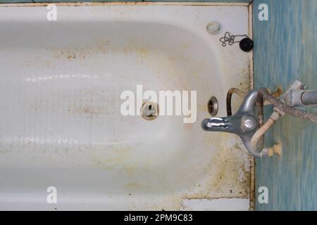 Il bagno era molto sporco. Bagno molto sporco, scarico dell'acqua, fognature, rubinetto miscelatore del rubinetto dell'acqua, fognature, doccia di troppo pieno. Sporcizia e ruggine nella vasca da bagno. Pulito Foto Stock