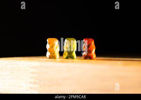 Gli orsi gommoso giocano su un tavolo da pranzo Foto Stock