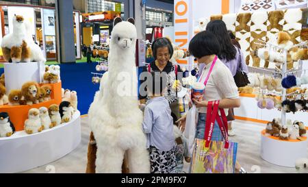 (230412) -- HAIKOU, 12 aprile 2023 (Xinhua) -- le persone visitano lo stand di un produttore australiano di giocattoli di peluche alpaca alla terza China International Consumer Products Expo (CICPE) a Haikou, nella provincia Hainan della Cina meridionale, 12 aprile 2023. La terza edizione della China International Consumer Products Expo, tenutasi nella provincia meridionale dell'Hainan, ha visto la partecipazione attiva delle imprese dei paesi membri del Regional Comprehensive Economic Partnership (RCEP), come Giappone, Corea del Sud, Australia e Thailandia. Le imprese provengono da importanti settori di consumo come profumi e sapori, cosmetici, alimenti, Foto Stock