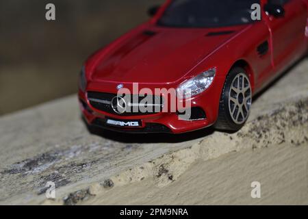 Elegante ed elegante, questo Maisto Mercedes Benz in scala 1:1:24 è il sogno di un collezionista di auto giocattolo che diventa realtà. Questo scatto da vicino è di colore rosso brillante. Foto Stock