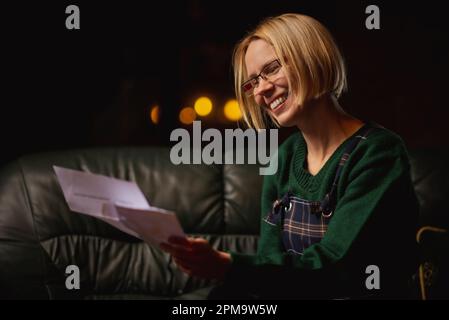 Donna allegra lettera tiene. Attraente donna di mezza età con un'espressione felice legge le notizie piacevoli da una lettera nel paese. Foto Stock