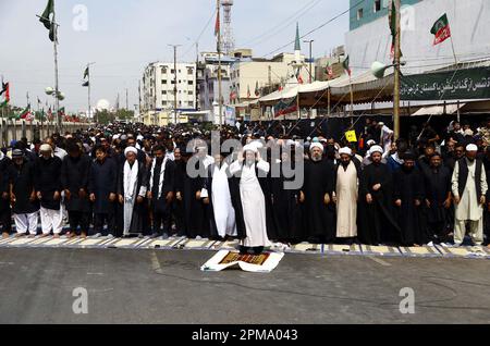 Karachi, Pakistan, 12 aprile 2023. I musulmani sciiti che piangono a Hazrat Ali al-Murtaza (A.S) stanno offrendo la preghiera Salat-e-Zohrain in occasione di Yum-e-Ali (A.S), il giorno del martirio 21st Ramadan-ul-Mubarak, sulla strada di M.A Jinnah a Karachi mercoledì 12 aprile 2023. Foto Stock