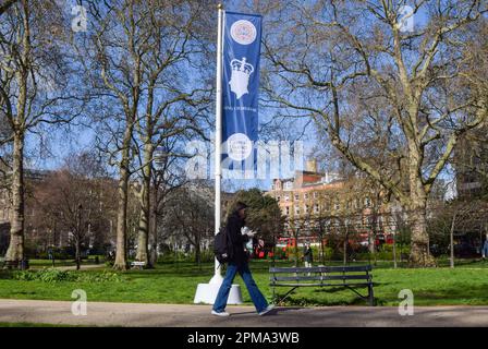 Londra, Regno Unito. 12th aprile 2023. Una donna passa davanti a una bandiera di incoronazione di Re Carlo III in Russell Square, davanti all'incoronazione, che si svolge il 6th maggio. Foto Stock