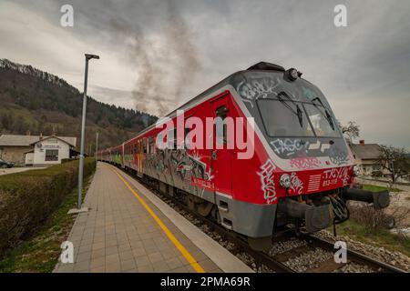 Stazione di sosta in Slovenia piccolo villaggio con unità diesel passeggeri vicino alla piattaforma in Podhom 03 30 2023 Foto Stock