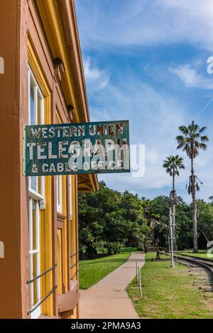 Cartello Western Union presso l'edificio della stazione ferroviaria di Goleta, California, con due palme sullo sfondo. Foto Stock