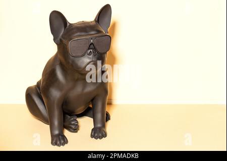 Giocattolo di sicurezza sotto forma di un bulldog francese nero con videosorveglianza e registrazione sonora contro una parete luminosa. Spazio di copia. Foto Stock