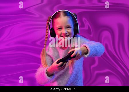 Ragazza allegra blondy bambino che gioca a videogiochi su sfondo astratto Foto Stock