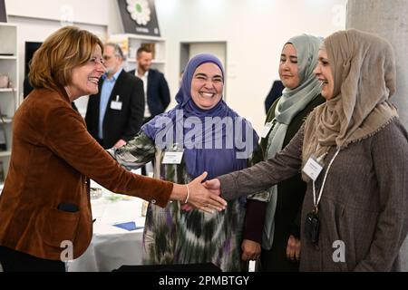 Magonza, Germania. 12th Apr, 2023. Malu Dreyer (SPD, l), Ministro Presidente della Renania-Palatinato, saluta tre donne che indossano il tradizionale hijab prima di rompere il digiuno nella sala banchetti della Comunità islamica dei bosniaci (IGDB). Durante il mese del digiuno del Ramadan, le comunità musulmane della Renania-Palatinato invitano anche i non musulmani a rompere il loro digiuno (iftar) in serata. Credit: Arne Dedert/dpa/Alamy Live News Foto Stock