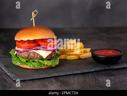 Fotografia alimentare di cheeseburger, hamburger, hamburger, salsa, formaggio, patatine fritte, lattuga, cipolla, pomodoro Foto Stock