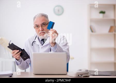 Medico anziano in concetto di remunerazione Foto Stock