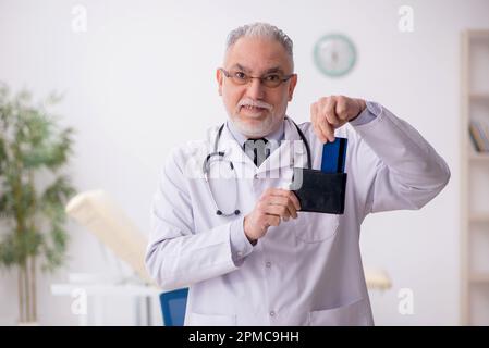 Medico anziano in concetto di remunerazione Foto Stock