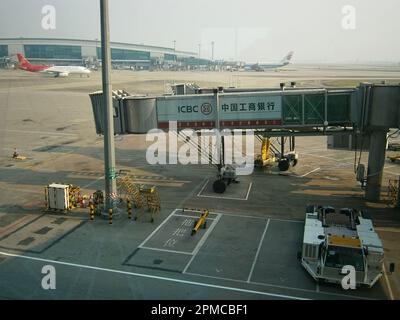 Un jet bridge con aerei sullo sfondo visto dal terminal dell'Aeroporto Internazionale di Baiyun. Foto Stock