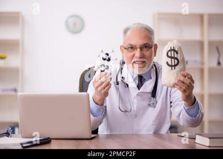 Medico anziano in concetto di remunerazione Foto Stock