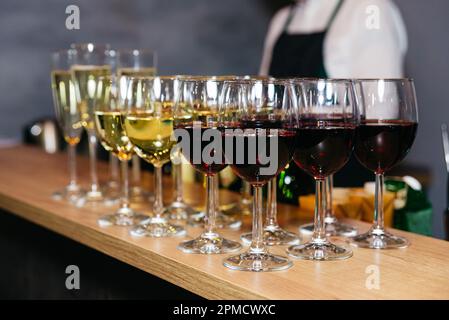 Bicchieri di vini diversi al banco del bar, vista ravvicinata Foto Stock