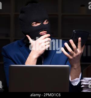 Il dipendente di sesso maschile di rubare informazioni in ufficio tempo di notte Foto Stock