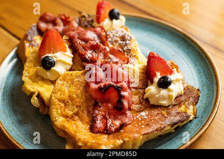 Toast alla francese con pane artigianale, fragole, mirtilli e sciroppo d'acero Foto Stock