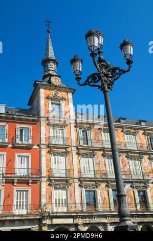 Casa de la Panaderia, Plaza Mayor, Madrid, Spagna, Europa. Una delle due torri con una facciata colorata di dipinti murali incorniciata da un palo ornato da lampada. Foto Stock