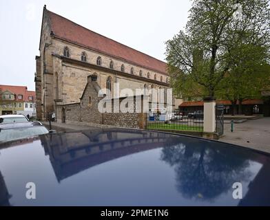 Erfurt, Germania. 12th Apr, 2023. La Predigerkirche si riflette sul tetto di un'auto. Il 15 aprile 2023 si terrà nella Predigerkirche un rave techno sotto il motto "Rave Like God". La festa di ballo è prevista insieme alla gioventù protestante e al nightclub 'Kalif Storch'. Soprattutto i giovani sono da raggiungere, che altrimenti difficilmente hanno un legame con la chiesa. Oltre alla tariffa d'ingresso, i visitatori devono fare una donazione di cibo per la banca di cibo di Erfurt all'ingresso. Credit: Martin Schutt/dpa/Alamy Live News Foto Stock