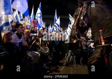 Israele. 12th Apr, 2023. I manifestanti contro la riforma cantano e agitano la bandiera israeliana accanto a un cavallo di polizia al di fuori di una cerimonia Mimouna a Hadera in partecipazione del primo ministro Benjamin Netanyahu. Apr 12th 2023. (Matan Golan/Sipa USA) Credit: Sipa USA/Alamy Live News Foto Stock