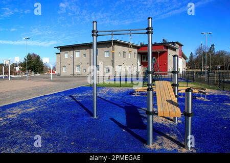 La moderna scuola elementare Kirkonkylän koulu e il cortile sportivo con attrezzature per il fitness all'aperto. Perniö, Salo, Finlandia. Aprile 9, 2023. Foto Stock