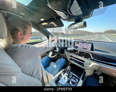 Donna bionda in auto in autostrada Foto Stock