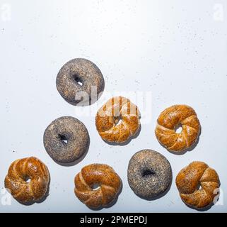 Vista dall'alto di quattro piccoli bagel appena sfornati con semi di chia e papavero Foto Stock